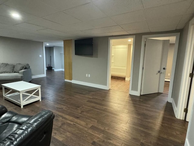 living room featuring dark wood-type flooring, a baseboard radiator, and a paneled ceiling