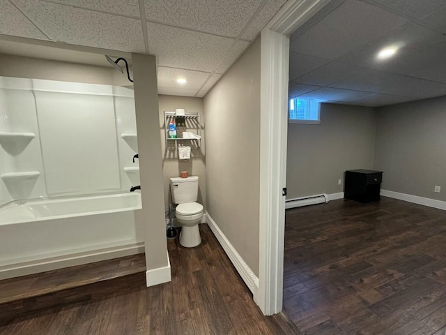 bathroom with toilet, a paneled ceiling, shower / bathing tub combination, a baseboard radiator, and hardwood / wood-style floors