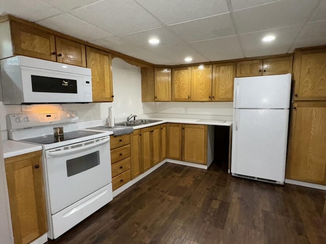 kitchen featuring dark hardwood / wood-style flooring, sink, a paneled ceiling, and white appliances