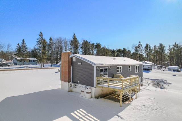 snow covered rear of property featuring a wooden deck