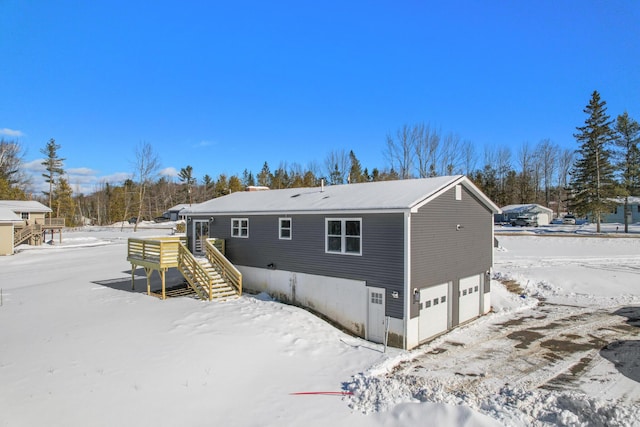 snow covered house featuring a garage