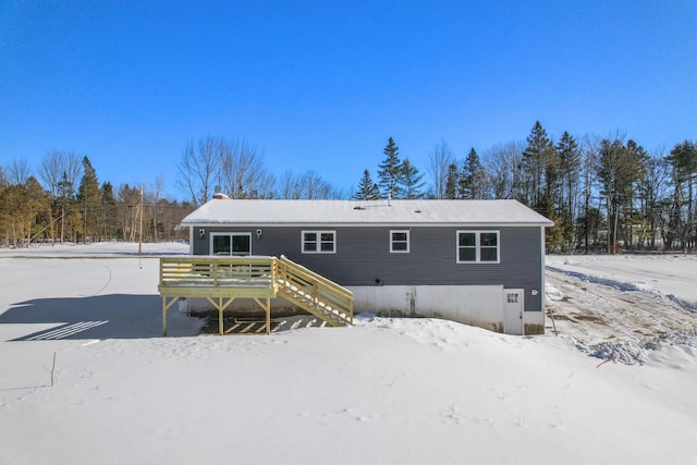 snow covered house with a wooden deck