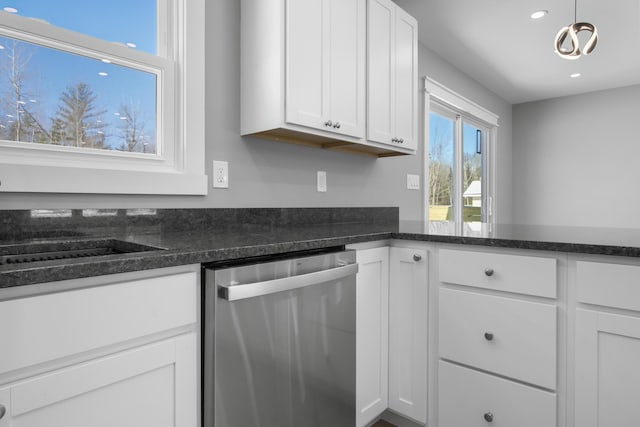 kitchen featuring hanging light fixtures, dishwasher, dark stone countertops, and white cabinets