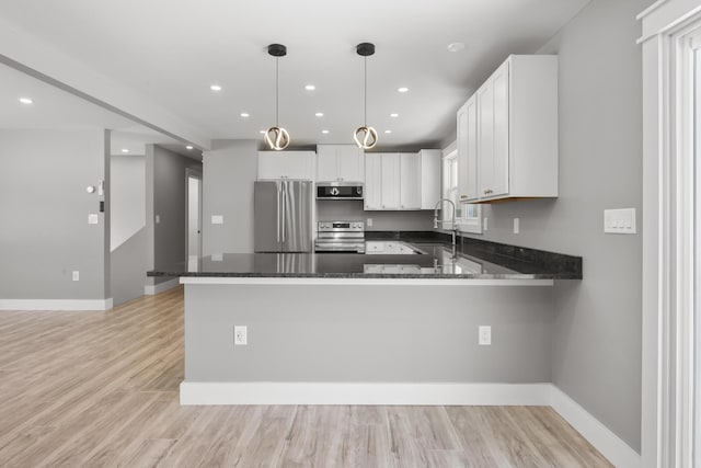 kitchen featuring sink, decorative light fixtures, kitchen peninsula, stainless steel appliances, and white cabinets