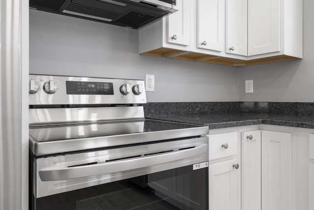 kitchen featuring white cabinetry, electric range, and ventilation hood