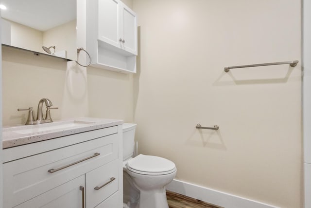 bathroom featuring vanity, hardwood / wood-style floors, and toilet