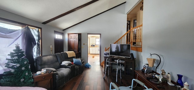 living room featuring vaulted ceiling with beams, dark wood-type flooring, and a textured ceiling