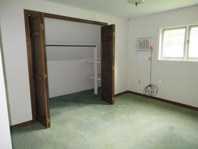 236 Frenchs Mill Rd, Sangerville, ME 04479 - unfurnished bedroom with light colored carpet, an AC wall unit, and baseboards