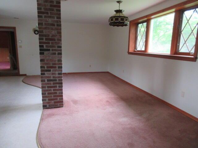 236 Frenchs Mill Rd, Sangerville, ME 04479 - empty room featuring carpet, baseboards, and decorative columns