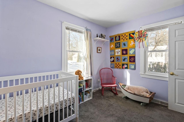 bedroom featuring dark colored carpet and a nursery area