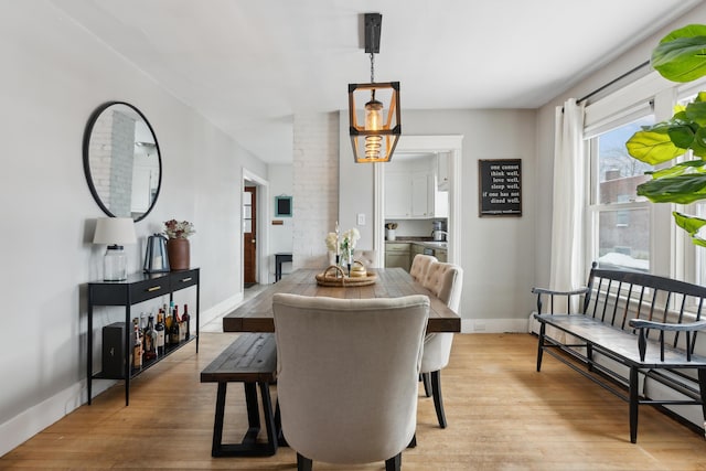 dining area with a baseboard heating unit and light hardwood / wood-style floors