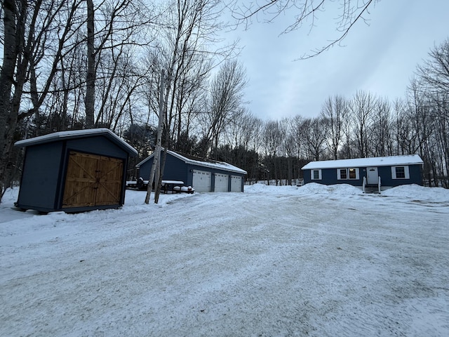 yard covered in snow with an outbuilding and a garage