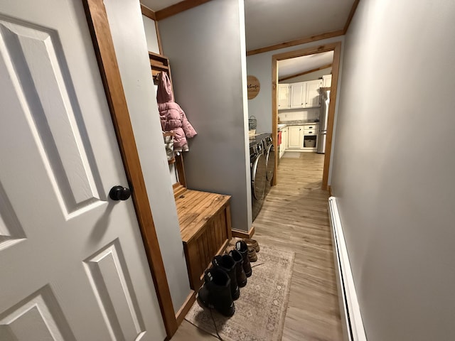 mudroom with separate washer and dryer, light wood-type flooring, and baseboard heating