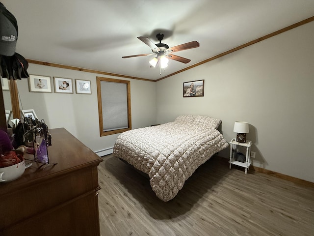 bedroom with a baseboard heating unit, ornamental molding, hardwood / wood-style floors, and ceiling fan