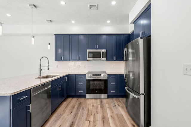 kitchen featuring blue cabinets, sink, hanging light fixtures, kitchen peninsula, and stainless steel appliances