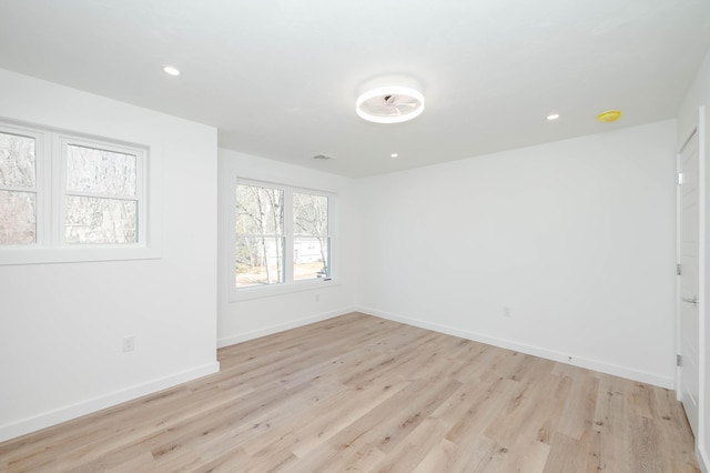 spare room featuring recessed lighting, baseboards, and light wood-style floors