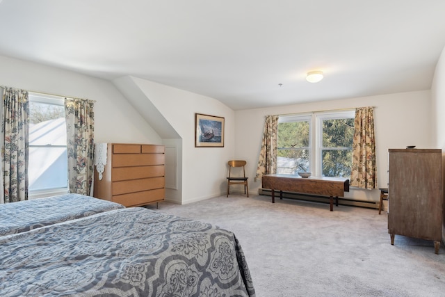 bedroom with baseboard heating, vaulted ceiling, and light colored carpet