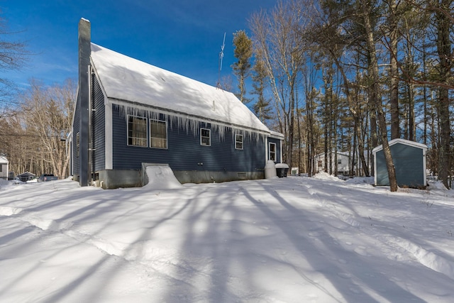 view of front of property with a storage shed, an outbuilding, and a chimney