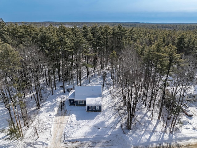 snowy aerial view featuring a forest view