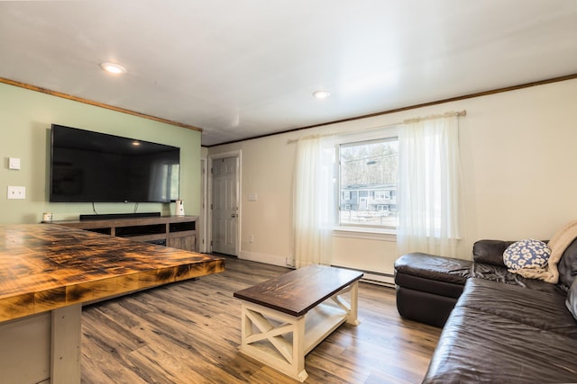 living area featuring crown molding, wood finished floors, and baseboards