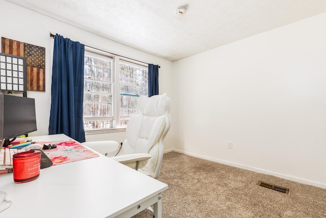 carpeted office with baseboards, visible vents, and a textured ceiling