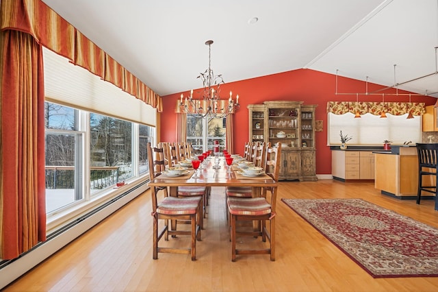 dining area featuring a chandelier, baseboard heating, lofted ceiling, and light wood-style floors