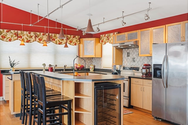 kitchen with wine cooler, dark countertops, appliances with stainless steel finishes, light wood-type flooring, and under cabinet range hood