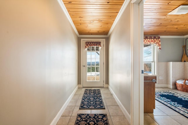 doorway to outside with wood ceiling, light tile patterned flooring, crown molding, and baseboards