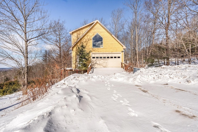 view of snow covered exterior with a garage