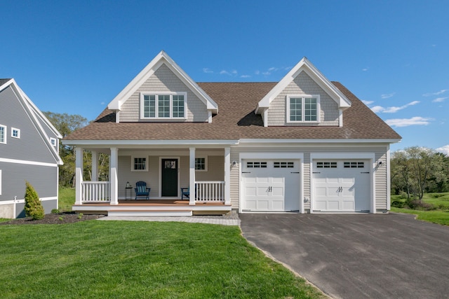 view of front of house featuring a garage, aphalt driveway, a front lawn, and a porch