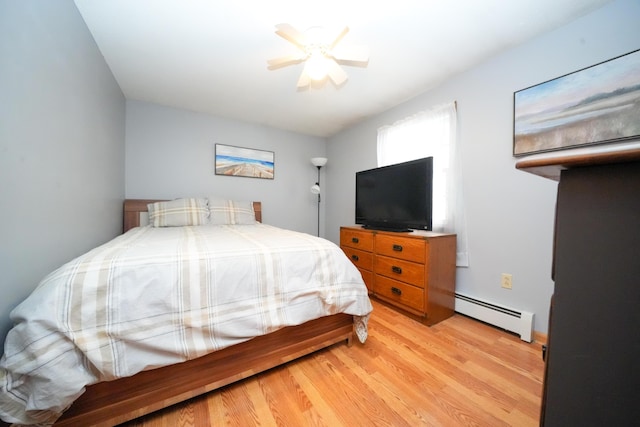 bedroom with a baseboard heating unit, ceiling fan, and light hardwood / wood-style flooring