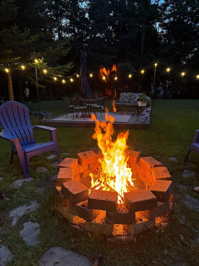 yard at twilight featuring a patio and a fire pit