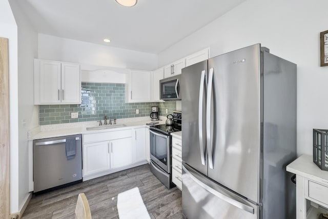 kitchen featuring sink, tasteful backsplash, appliances with stainless steel finishes, dark hardwood / wood-style flooring, and white cabinets