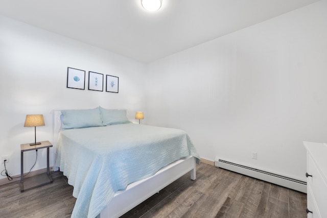 bedroom with dark wood-type flooring and a baseboard heating unit