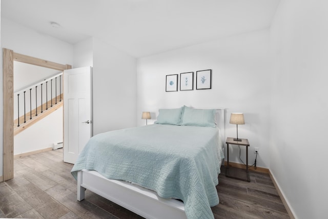 bedroom featuring hardwood / wood-style flooring and a baseboard heating unit