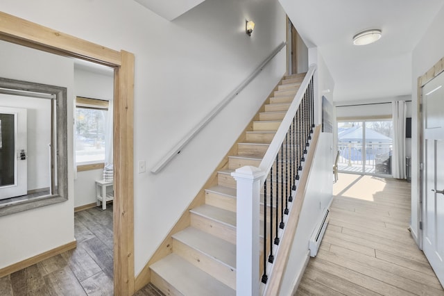 staircase with hardwood / wood-style flooring, plenty of natural light, and baseboard heating
