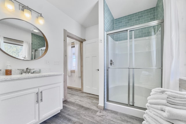 bathroom featuring vanity, hardwood / wood-style flooring, and a shower with shower door