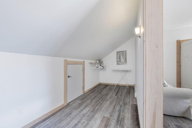 bonus room with hardwood / wood-style flooring and vaulted ceiling