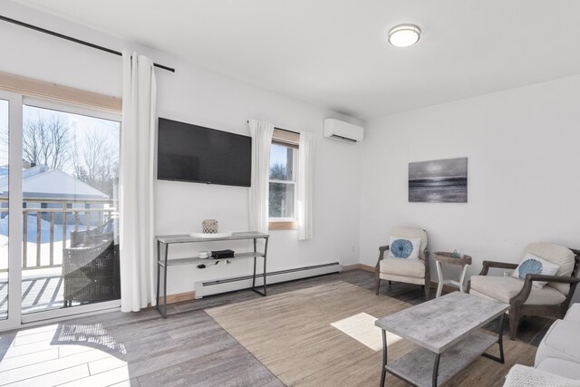 living room with a wall mounted air conditioner, a baseboard radiator, and light wood-type flooring