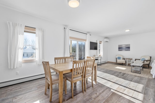 dining area with a wall unit AC and light wood-type flooring