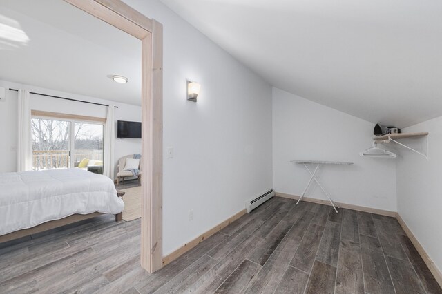 bedroom with a baseboard radiator, lofted ceiling, and dark hardwood / wood-style floors