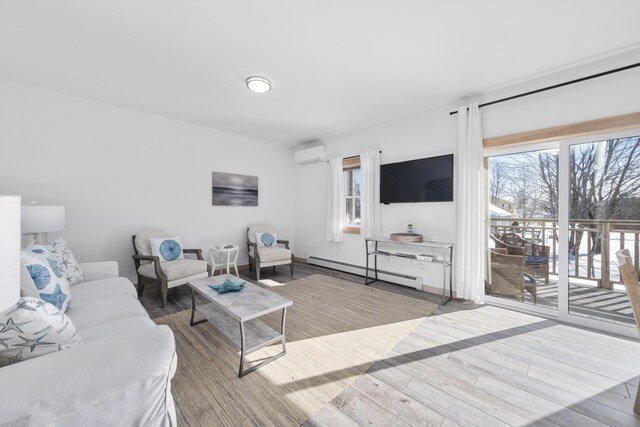 living room with a baseboard heating unit, light hardwood / wood-style flooring, and an AC wall unit