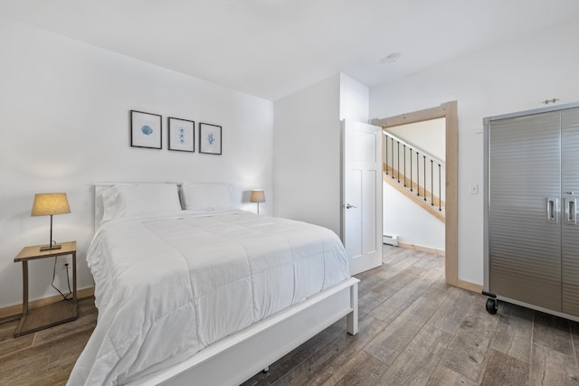 bedroom featuring hardwood / wood-style flooring and baseboard heating