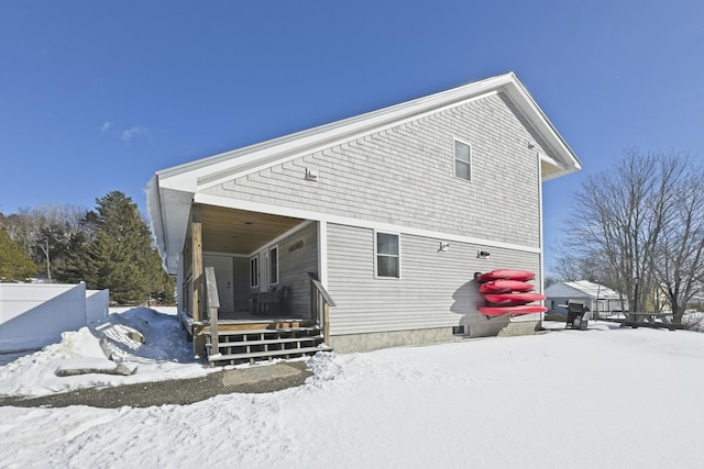 view of snow covered rear of property