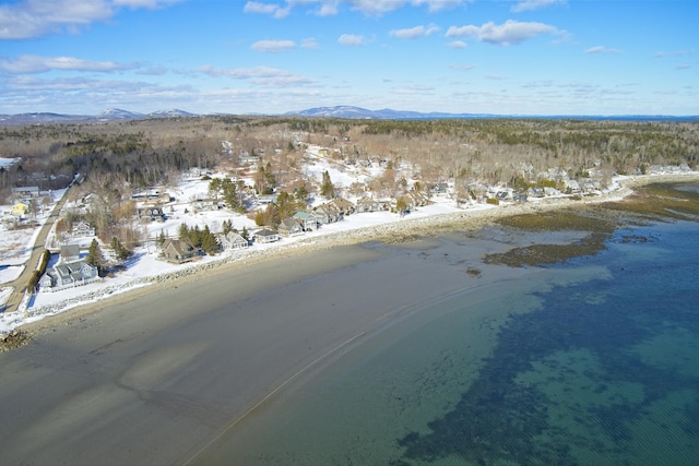 snowy aerial view with a water and mountain view