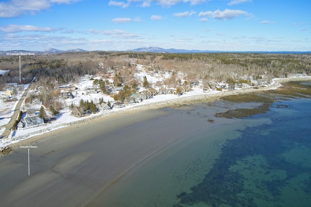 snowy aerial view with a water and mountain view