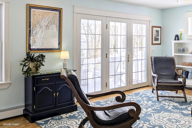 sitting room featuring light wood-type flooring and a baseboard heating unit