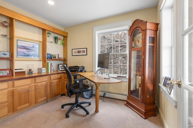 carpeted home office with a wealth of natural light and a baseboard heating unit