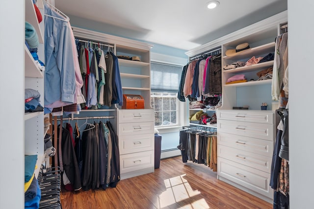 spacious closet with a baseboard heating unit and light hardwood / wood-style floors