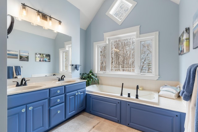 bathroom featuring tile patterned floors, vanity, vaulted ceiling, and a tub